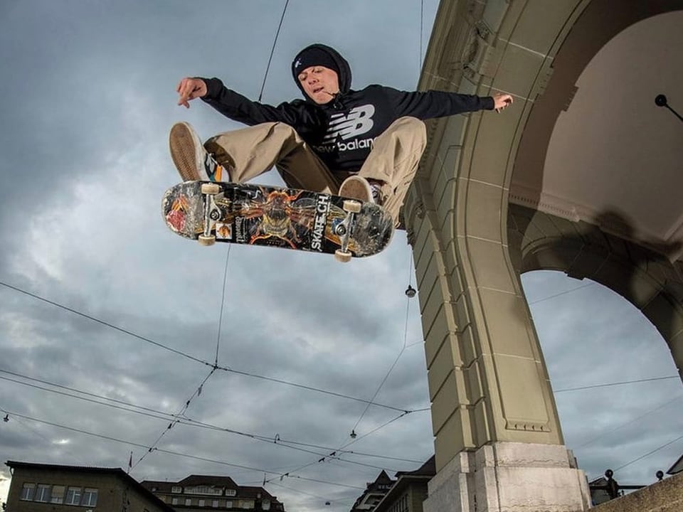 Mann mit Skateboard bei einem Sprung in der Luft