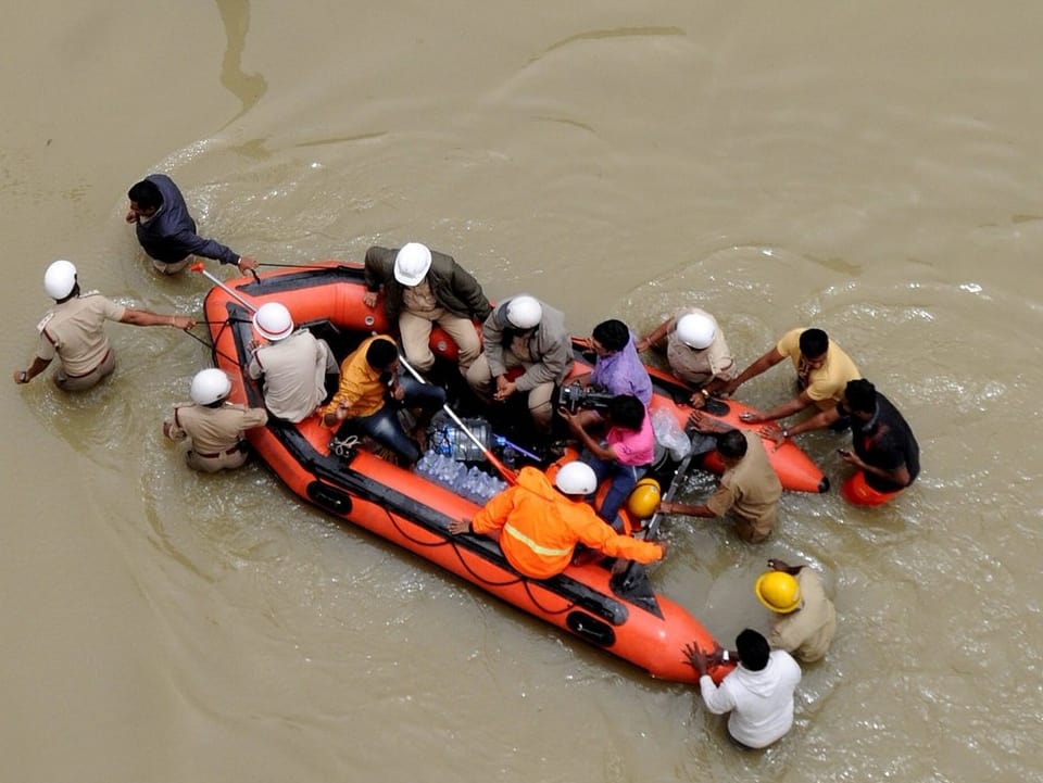 Rotes Schlauchboot aus der Luft fotografiert mit gretteten Bewohnern von Bangalore