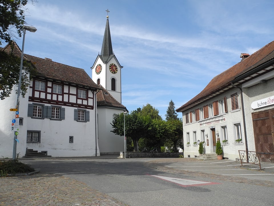 Kirche auf Platz mit Riegelhaus