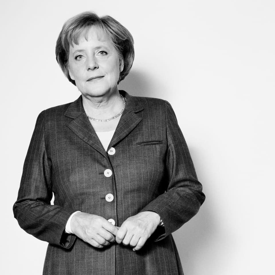 Frau in Anzug mit Kurzhaarschnitt und Kette (Angela Merkel)