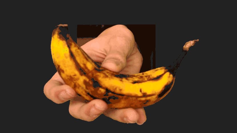 Eine Hand streckt dem Betrachter eine Banane entgegen.