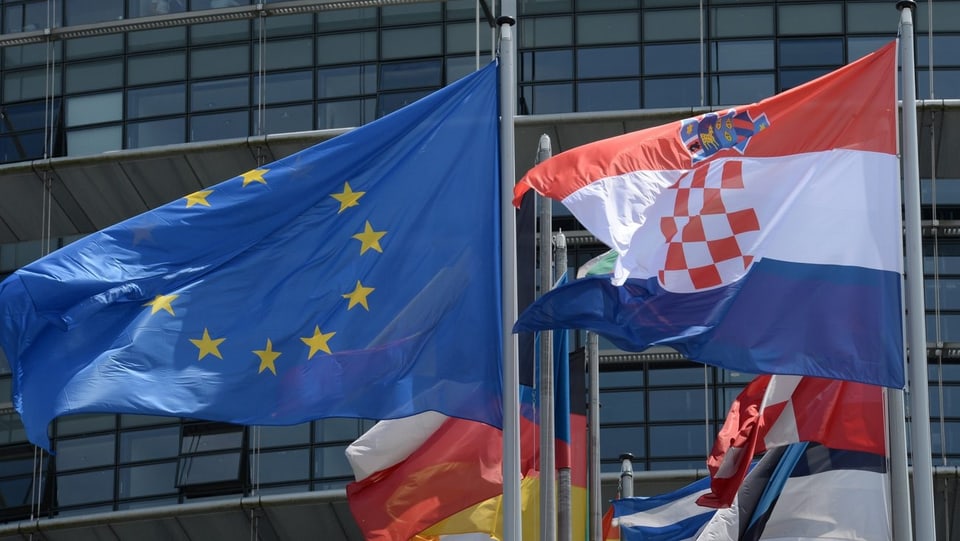 EU-Fahne und Kroatien-Fahne im Wind.