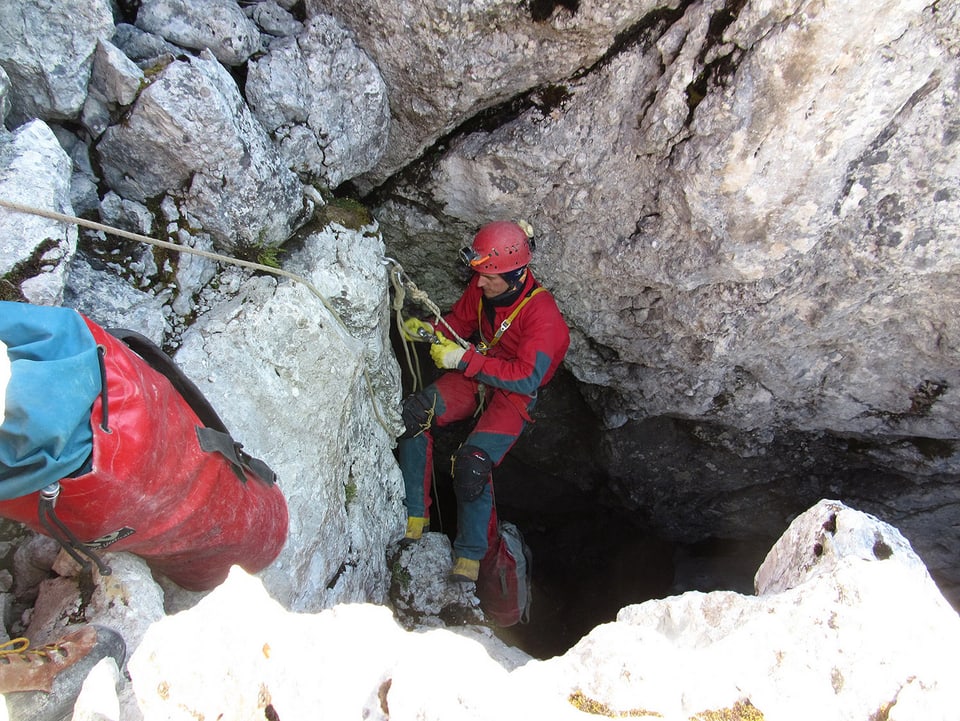 Ein Mitglied der Bergwacht seilt sich in eine Höhle herab. 