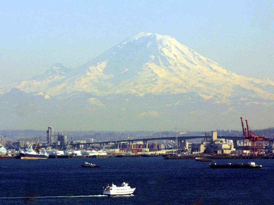 Verschneiter Vulkan Mount Rainier, im Vordergrund die Stadt Seattle