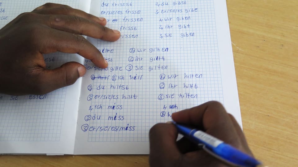 Ein Eritreer schreibt in ein Notizheft