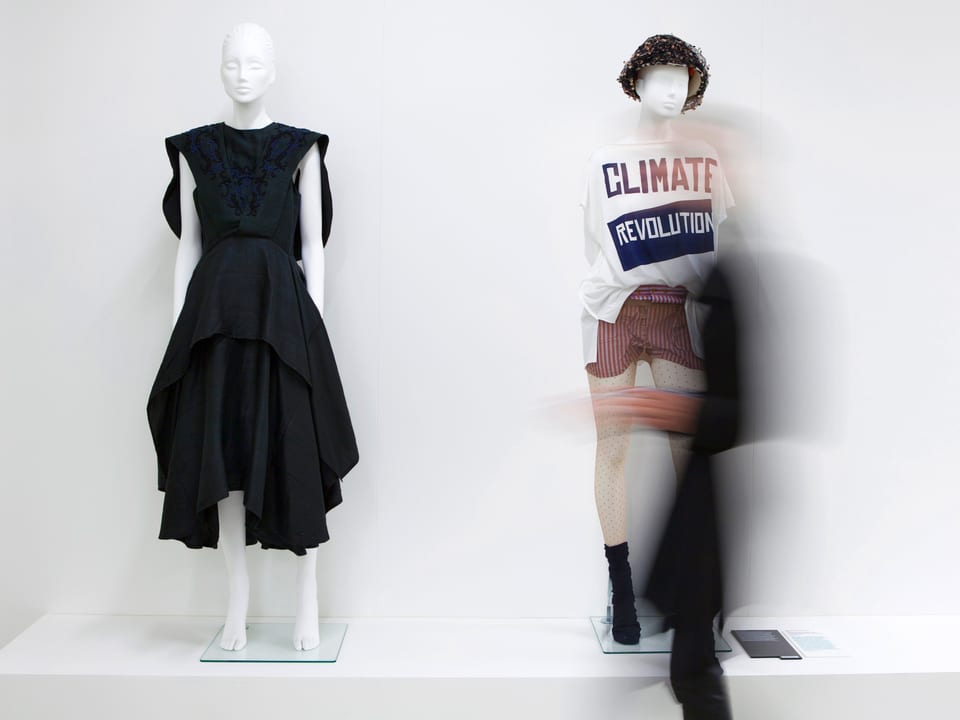 Zwei Puppen: eine mit schwarzem Kleid und eine mit einem T-Shirt mit der Aufschrift «Climate Revolution».