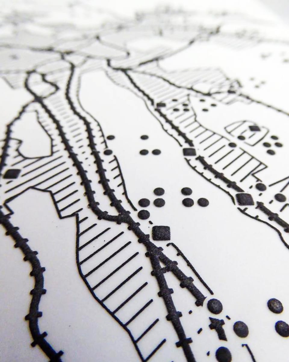 Landkarte mit Brailleschrift, Punkten und schraffierten Flächen.