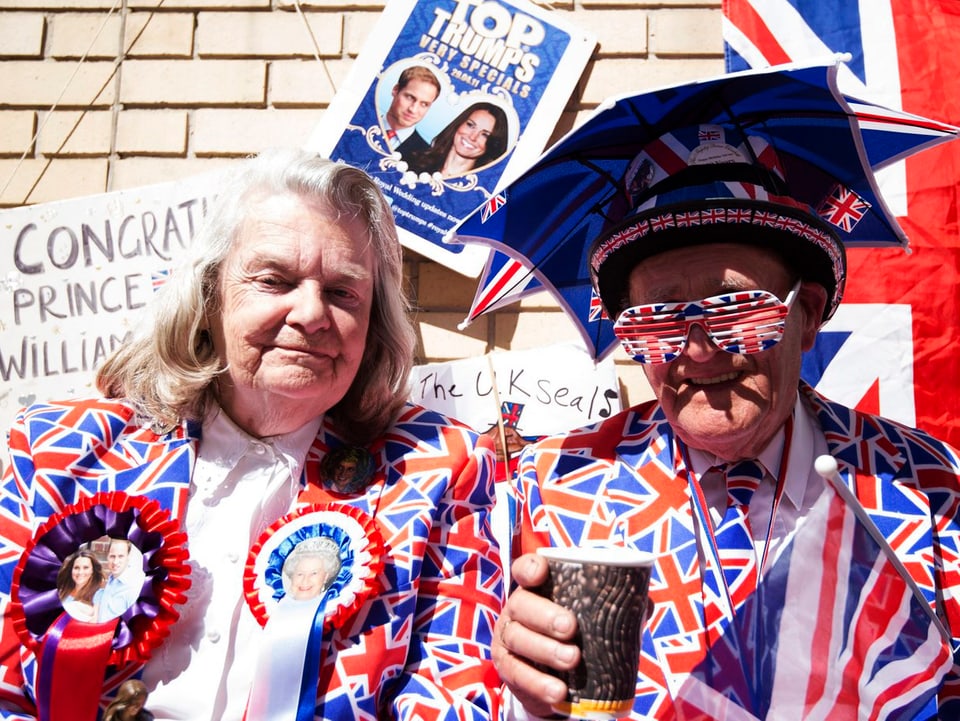 Zwei Fans in britischen Farben mit einem Pappbecher.