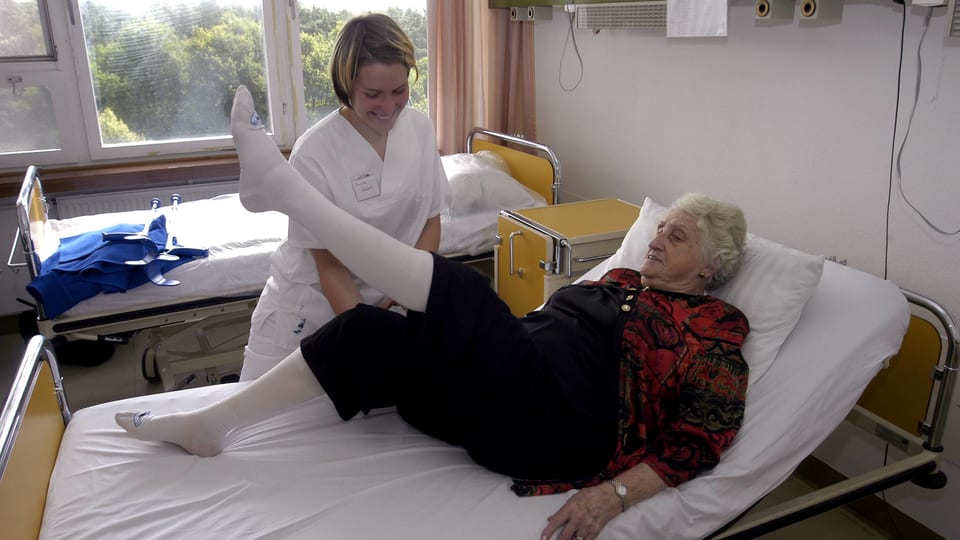 Pflegende hilft älterer Frau