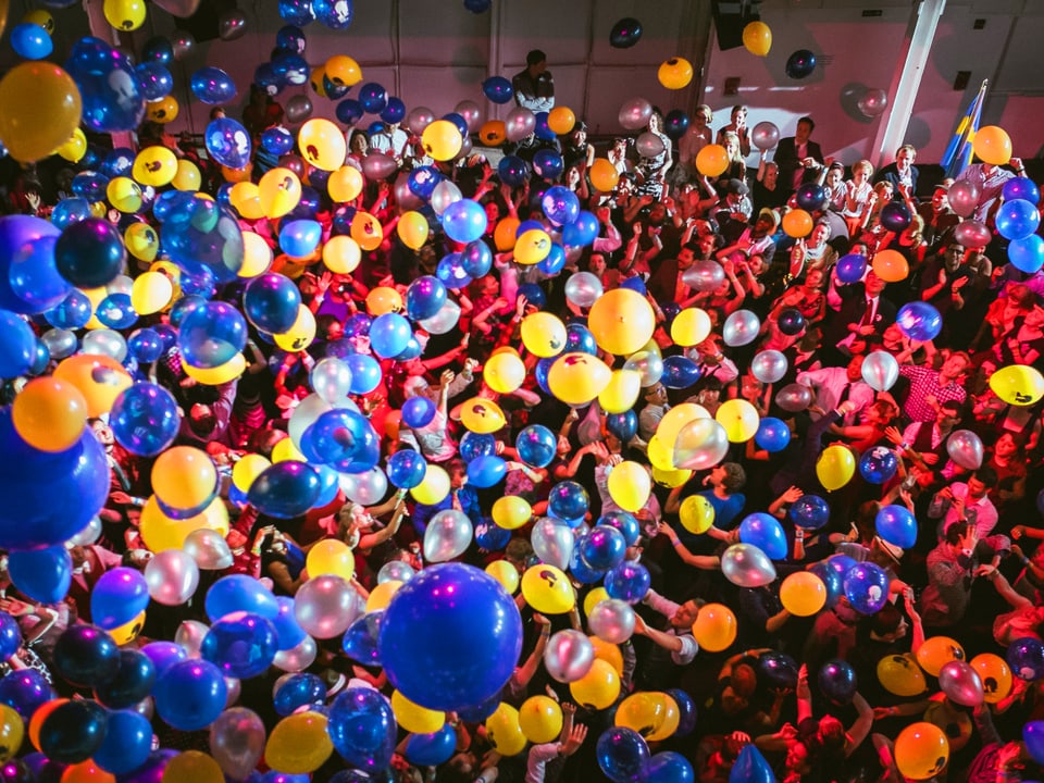 Farbige Luftballons und tanzende Menschen.