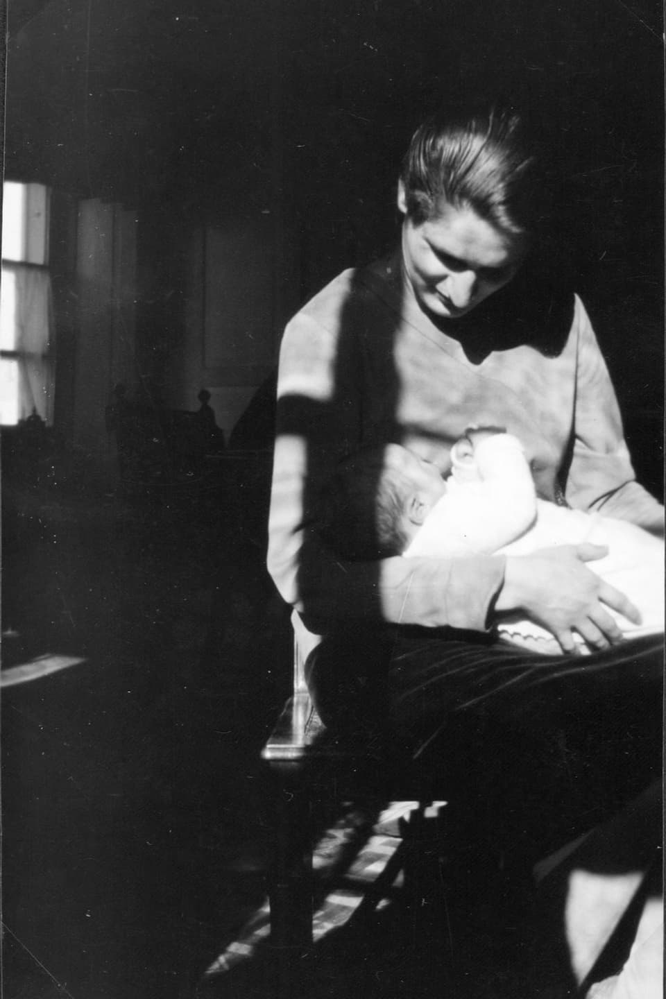 Schwarzweiss-Fotografie einer Frau mit Kleinkind.