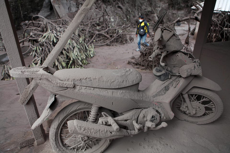 Die Asche des Vulkans begräbt Motorräder unter einer Aschedecke