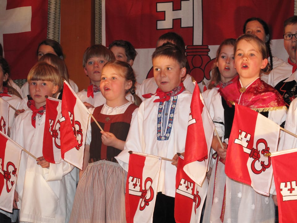 Kinder singen in Tracht Volkslieder.