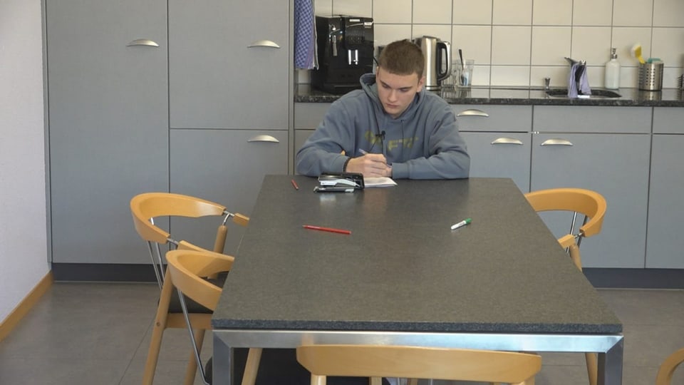 Der 15-Jährige sitzt an einem Tisch und nimmt virtuell am Fernunterrich teil.