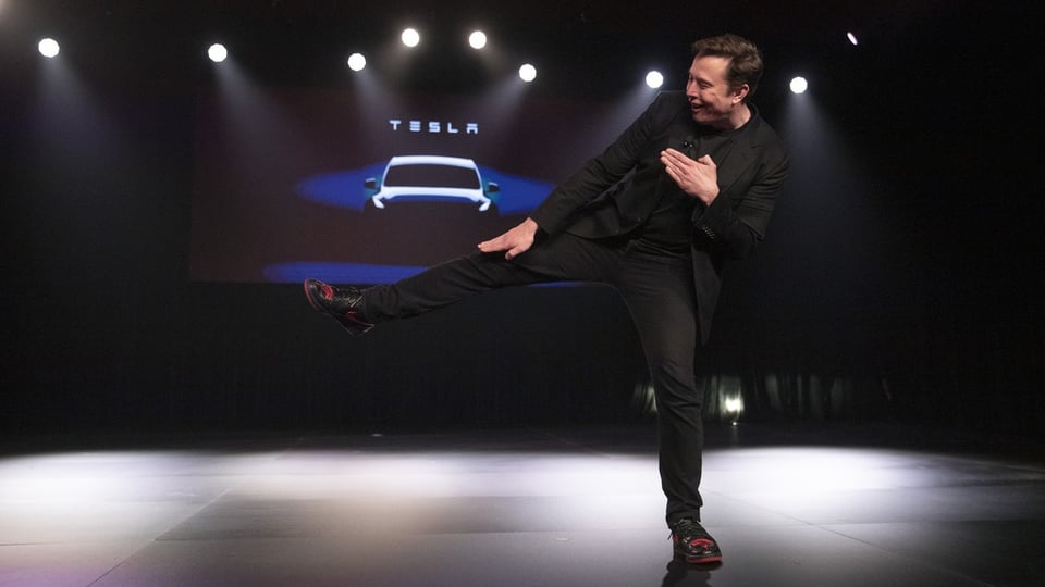 Tesla-CEO Elon Musk deutet scherzhaft einen Tritt an, bevor er das Model Y im Tesla-Designstudio vorstellt