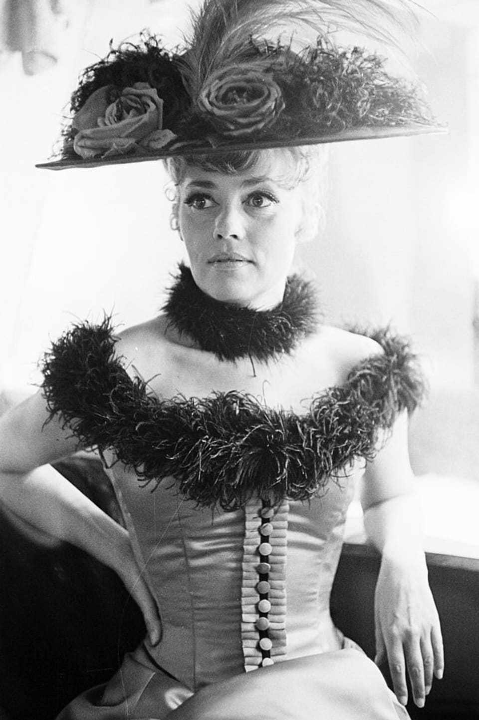 Jeanne Moreau mit Blumenhut und enger Korsage.