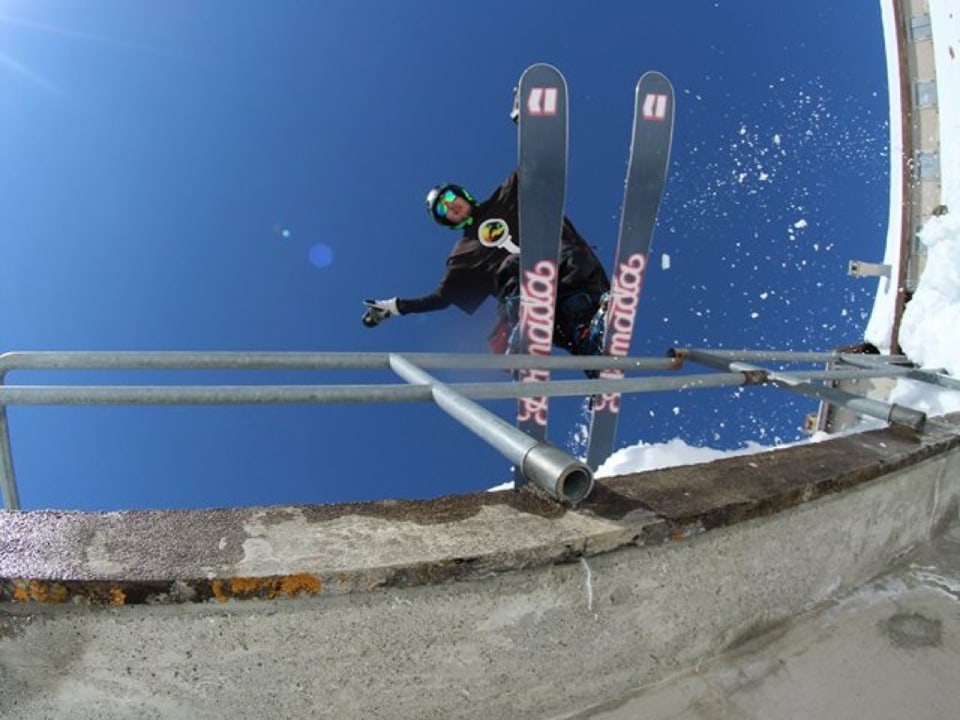 Nando Lötscher mit Ski auf Geländer.