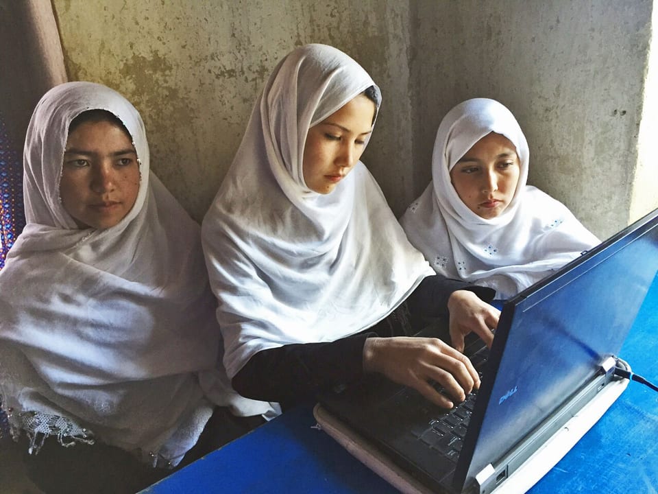 Drei Mädchen mit einem Laptop.